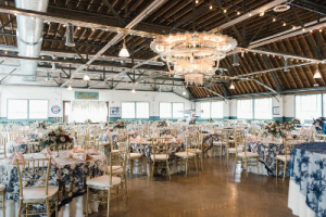 decorated room with a lovely chandelier and tables set for a fancy wedding